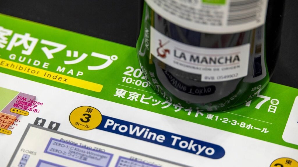 Material promocional de Prowine Tokyo junto a una botella de vino DO La Mancha en Japón