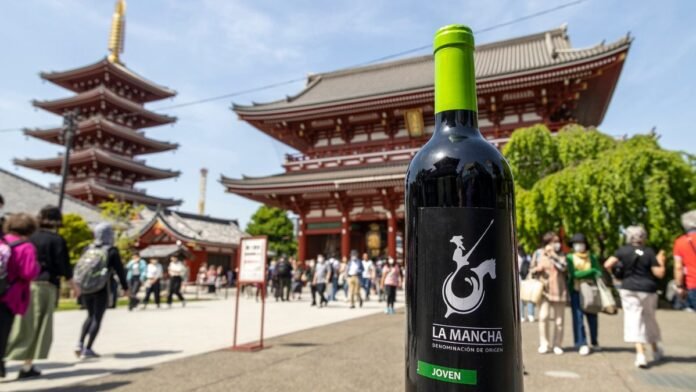 Botella de vino DO La Mancha frente a un templo tradicional en Tokio durante una acción promocional en Japón